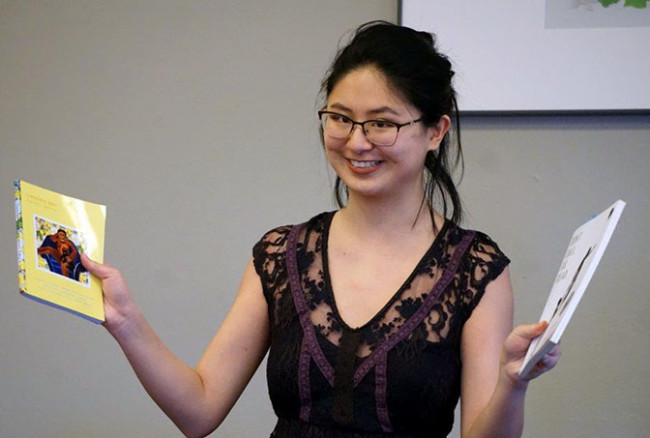 U of R student Erin O'Malley holds up 2 books 