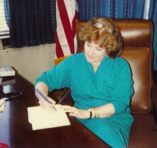 Congresswoman Louise Slaughter at a desk writing on a document