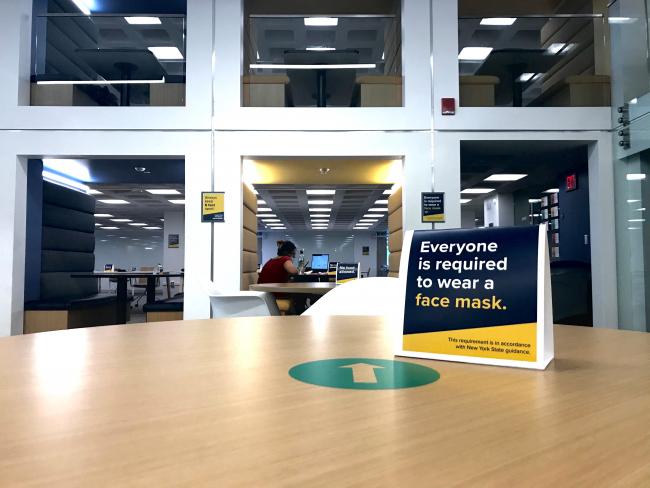 A view of iZone's booth seating and a COVID safety sign from the piazza