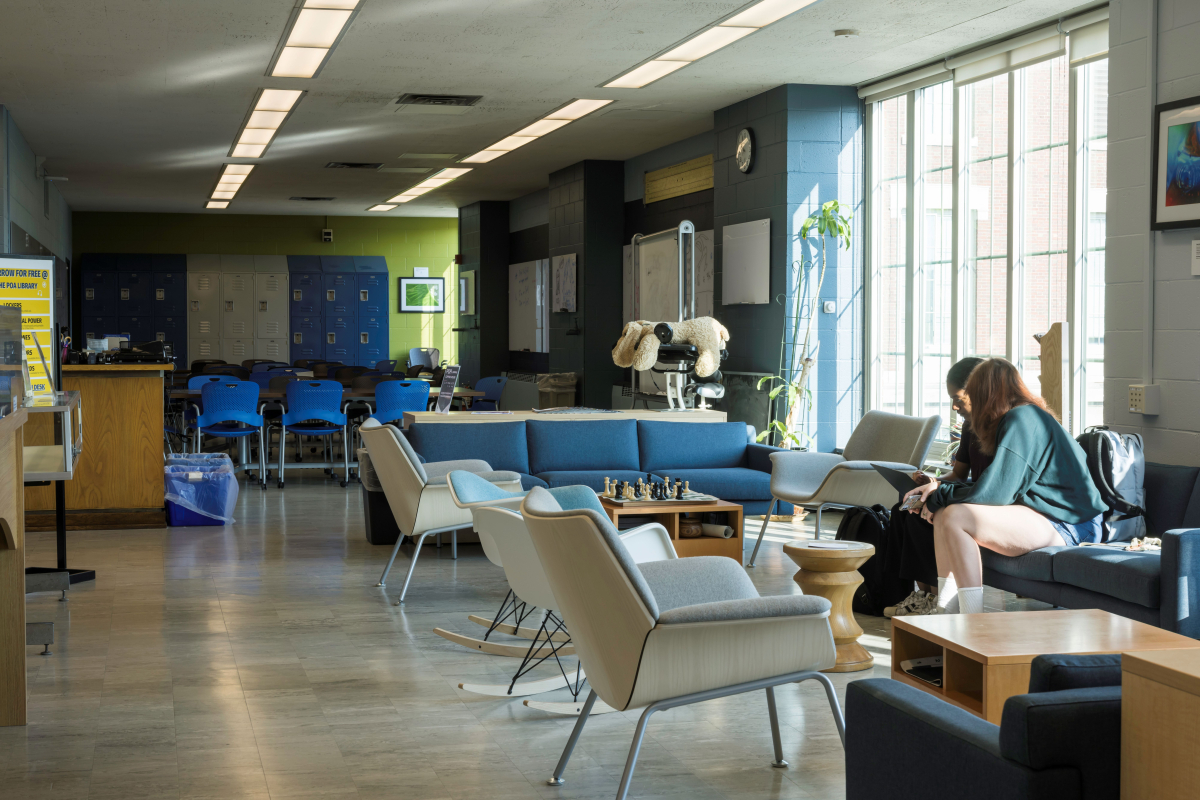 A view of POA's lounge area from where the stacks begin. Two students are sharing one of the couches
