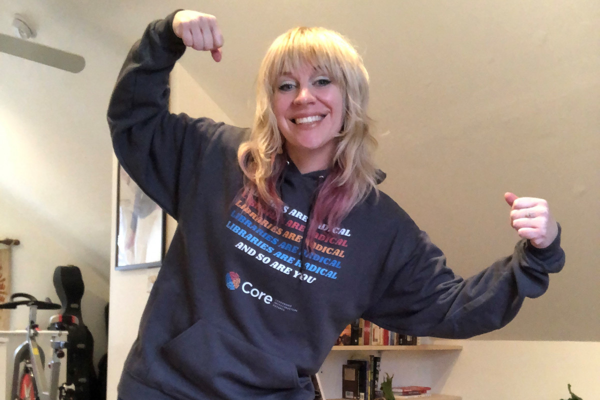 Lindsay Cronk, flexing and wearing a hoodie that says Libraries are radical. And so are you.