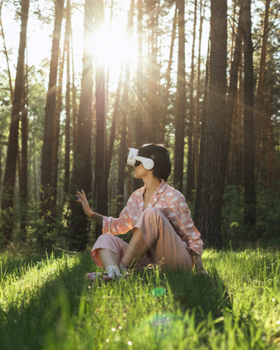 Person wearing a vr headset sitting outside. 