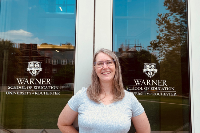 Eileen Daly-Boas standing in front of doors to LeChase Hall